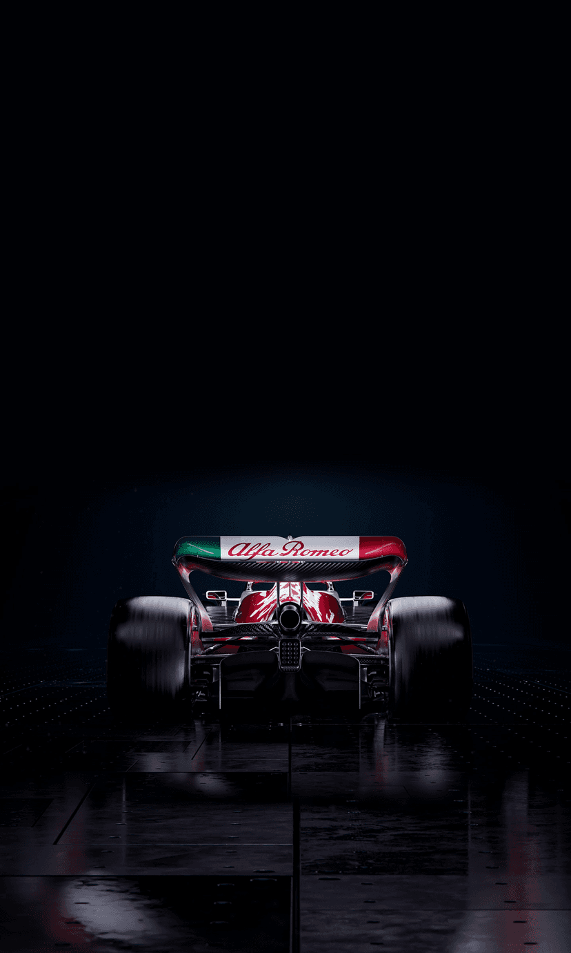 Alfa Romeo Formula 1 car rear showing the diffuser and Italian livery on a wet, dark racing track surface.