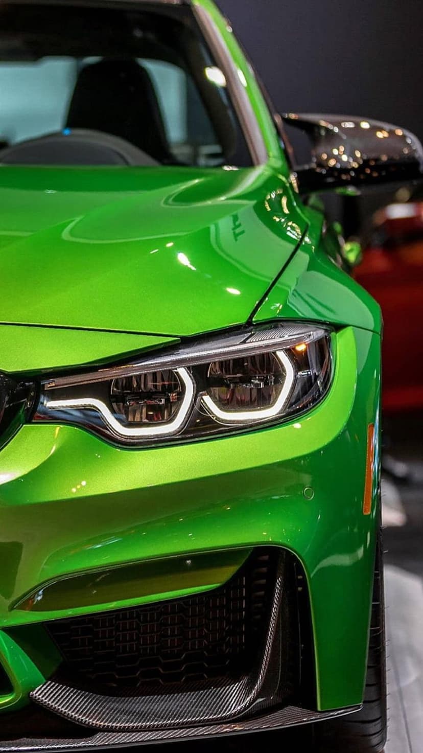 Lime green supercar headlight featuring sharp LED accents, a black mesh grille, and glossy metallic paint.