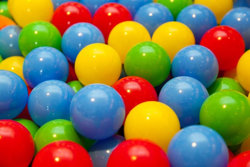 Vibrant red, yellow, and blue plastic spheres piled together with a soft focus background and macro detail.