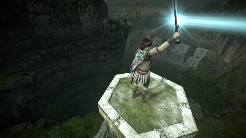 Wander raises the glowing Ancient Sword on a stone pillar overlooking a vast valley with waterfalls.