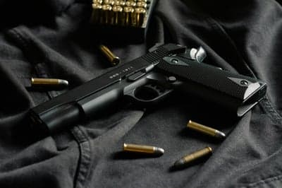 Black Handgun with Bullets on Dark Fabric