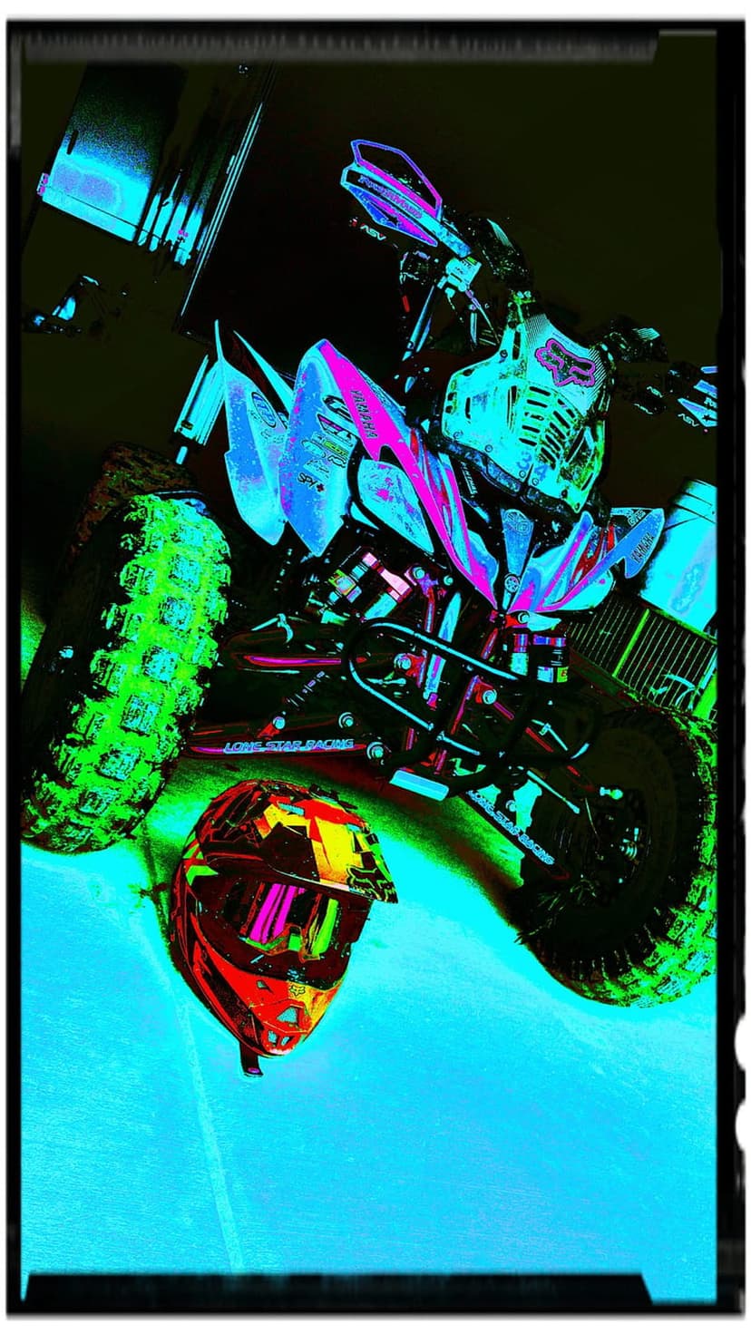 Quad bike with glowing neon green tires and a colorful helmet rests against a high-contrast dark background.