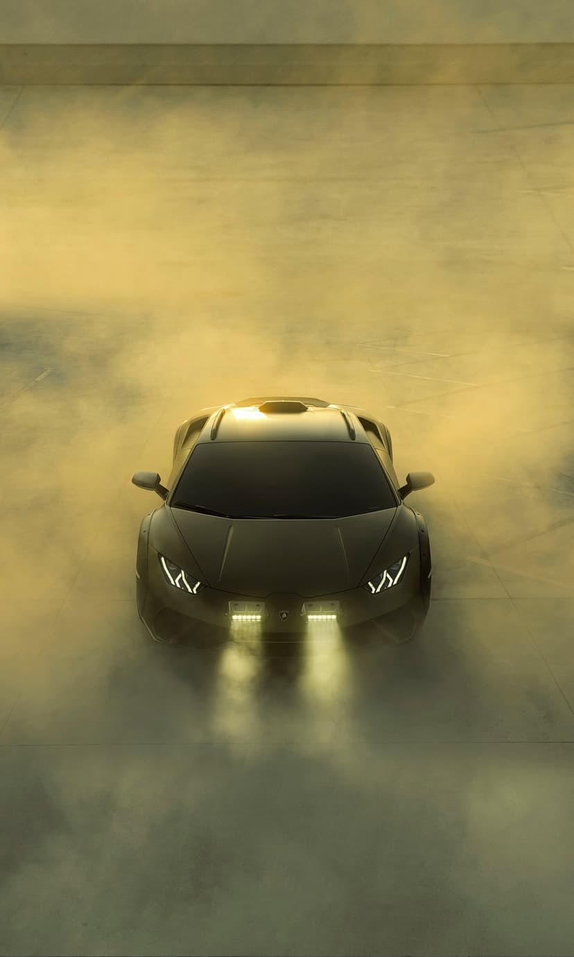 Black Lamborghini supercar with glowing LED headlights emerges from thick golden smoke at a high-angle view.