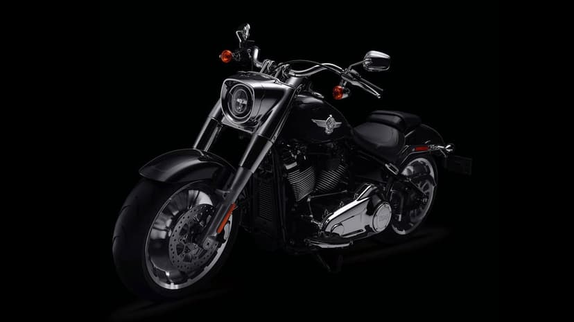 Black Harley-Davidson Fat Boy motorcycle with polished chrome accents against a solid black studio background.