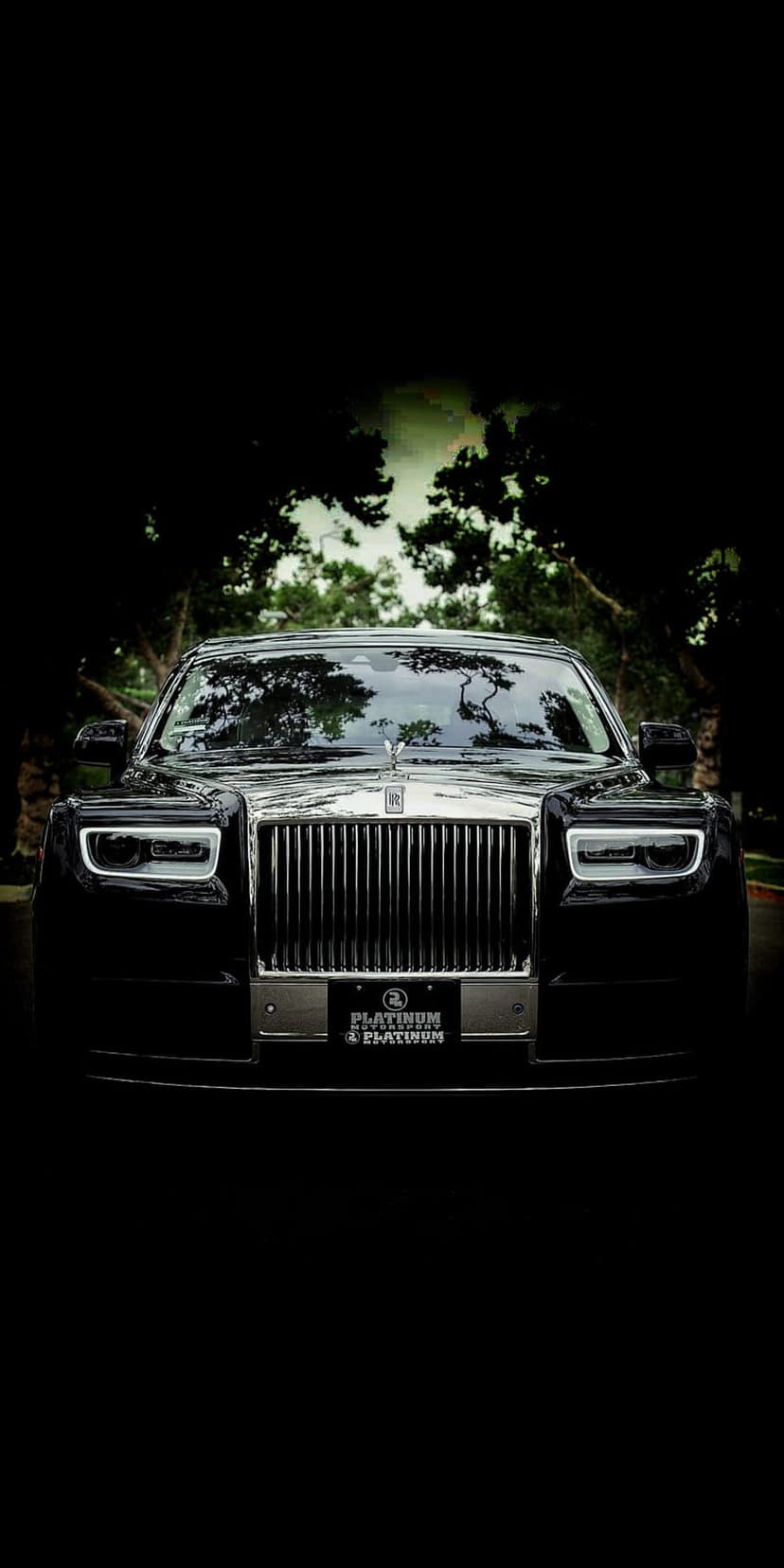 Black Rolls-Royce Phantom front view featuring a chrome grille, hood ornament, and platinum license plate.