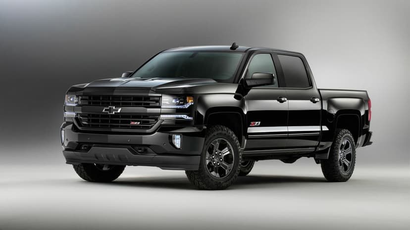 Black Chevrolet Silverado Z71 pickup truck with LED lights and off-road tires in a minimalist gray studio.