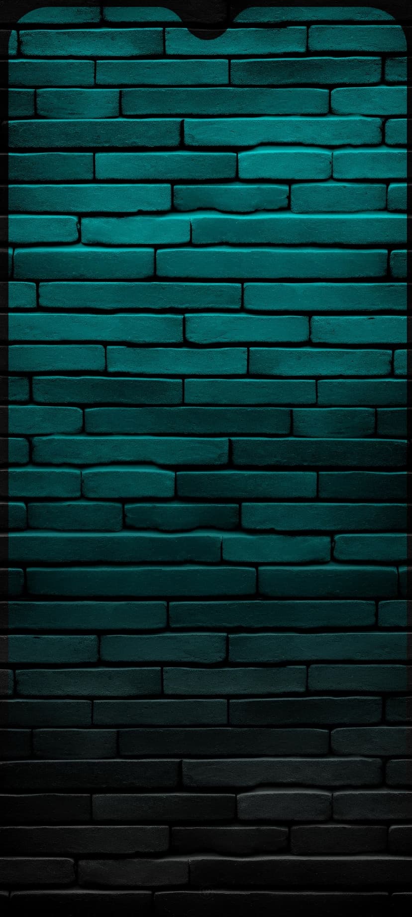 Teal brick wall showcasing rough masonry textures that gradually fade into a heavy dark gradient at the base.