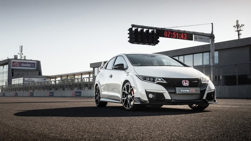 White Honda Civic Type R sports car on a sunny racetrack with starting lights and a digital timer background.