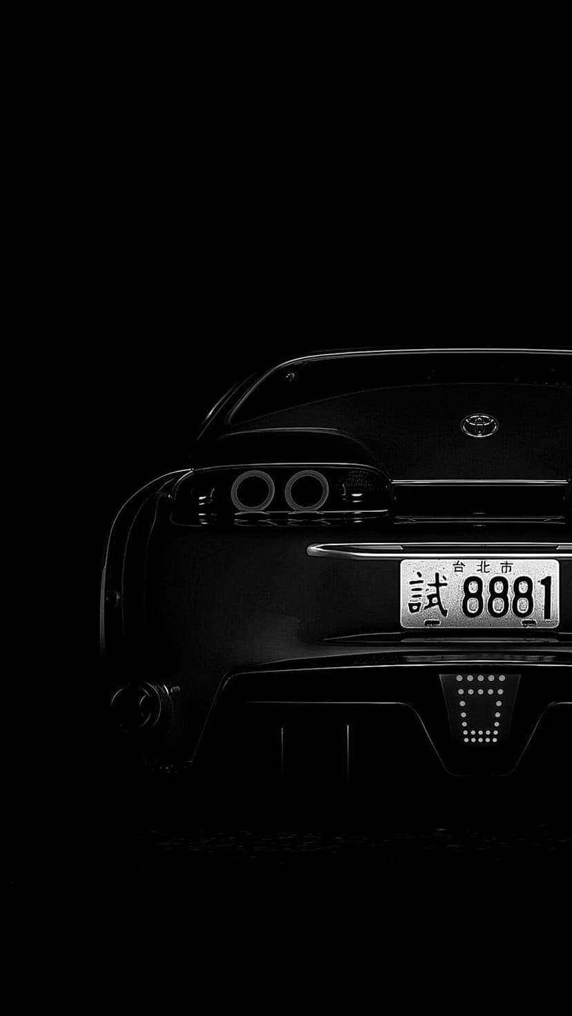 Toyota Supra rear taillights and custom license plate visible in a dark, moody automotive close-up.