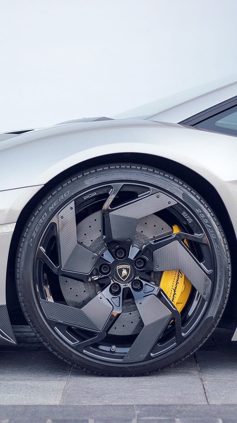 Lamborghini wheel with carbon fiber spokes, yellow brake calipers, and a Pirelli P Zero Nero tire in close-up.