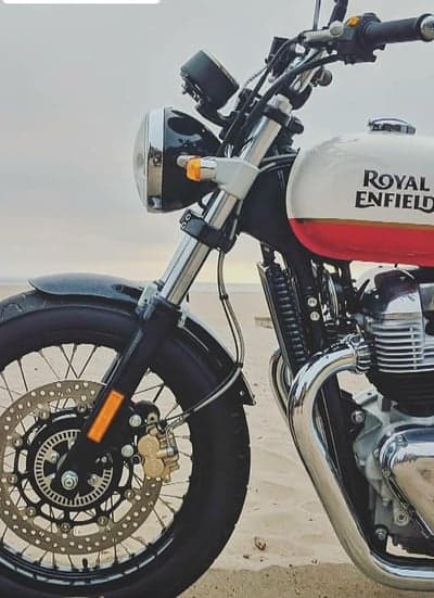 Royal Enfield motorcycle parked on a sandy beach