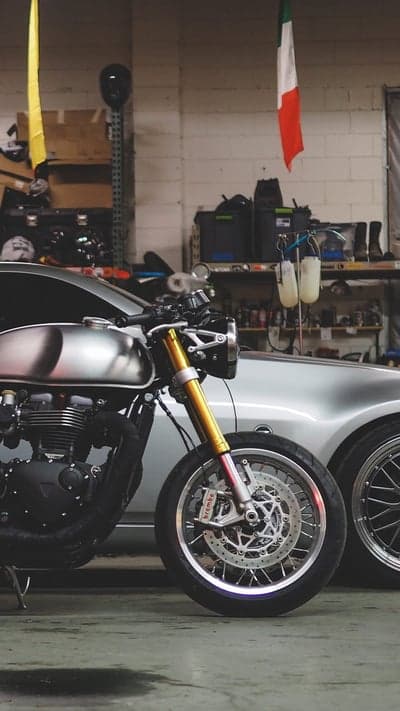 Classic Silver Motorcycle Next to Silver Car in Garage