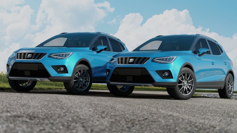 Two cyan SEAT SUVs parked on a gravel road against a bright blue sky with white clouds in a landscape view.