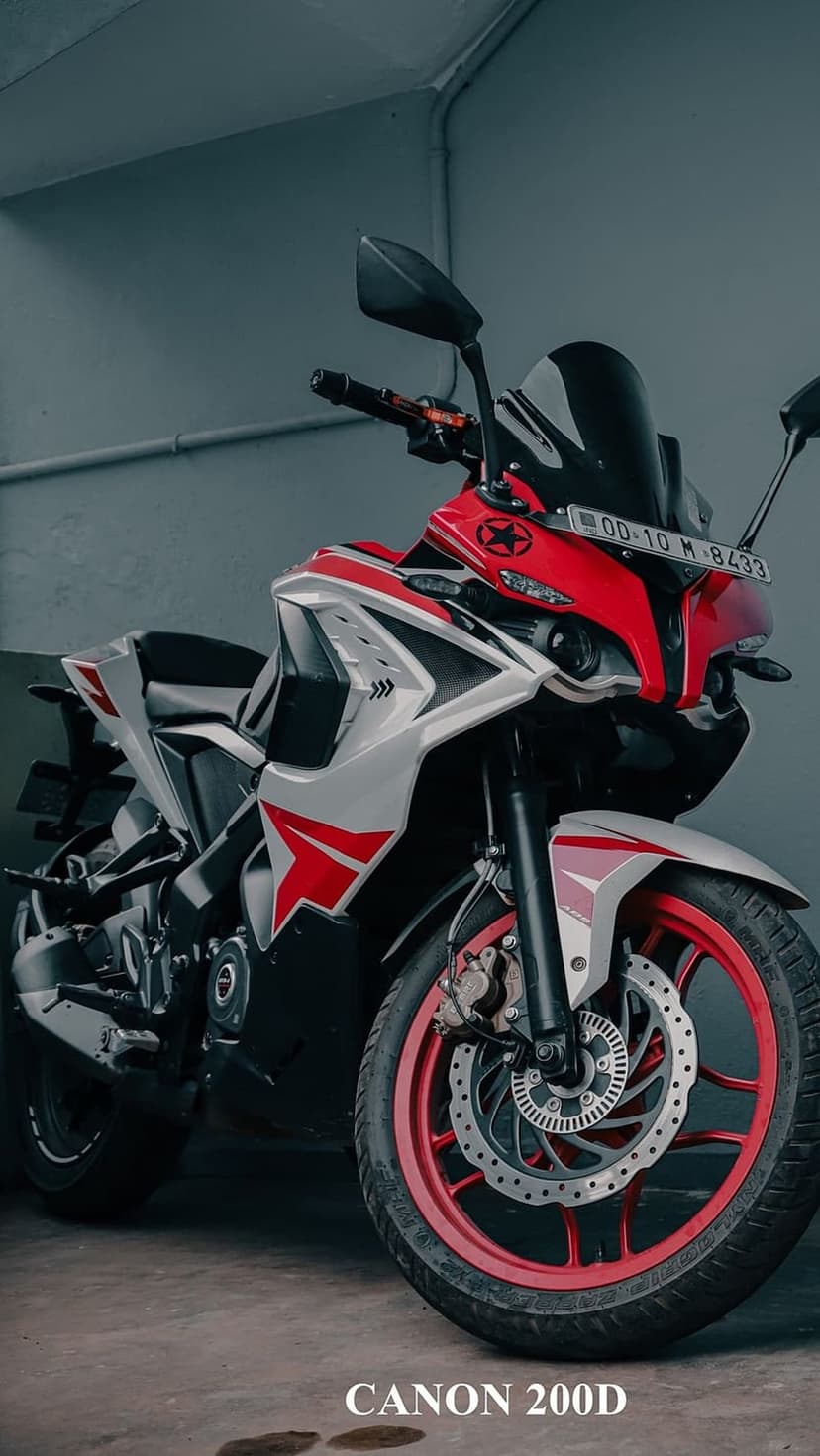 Red and white sport motorcycle with aggressive fairing parked on a grey concrete floor in portrait orientation.