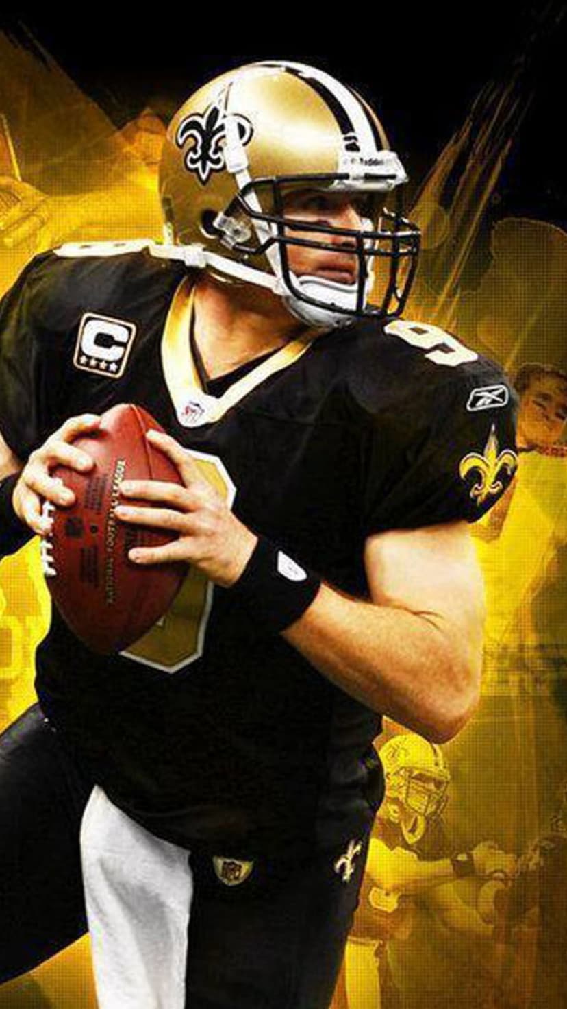 Drew Brees in a black New Orleans Saints jersey holds a football against a blurred yellow and gold background.