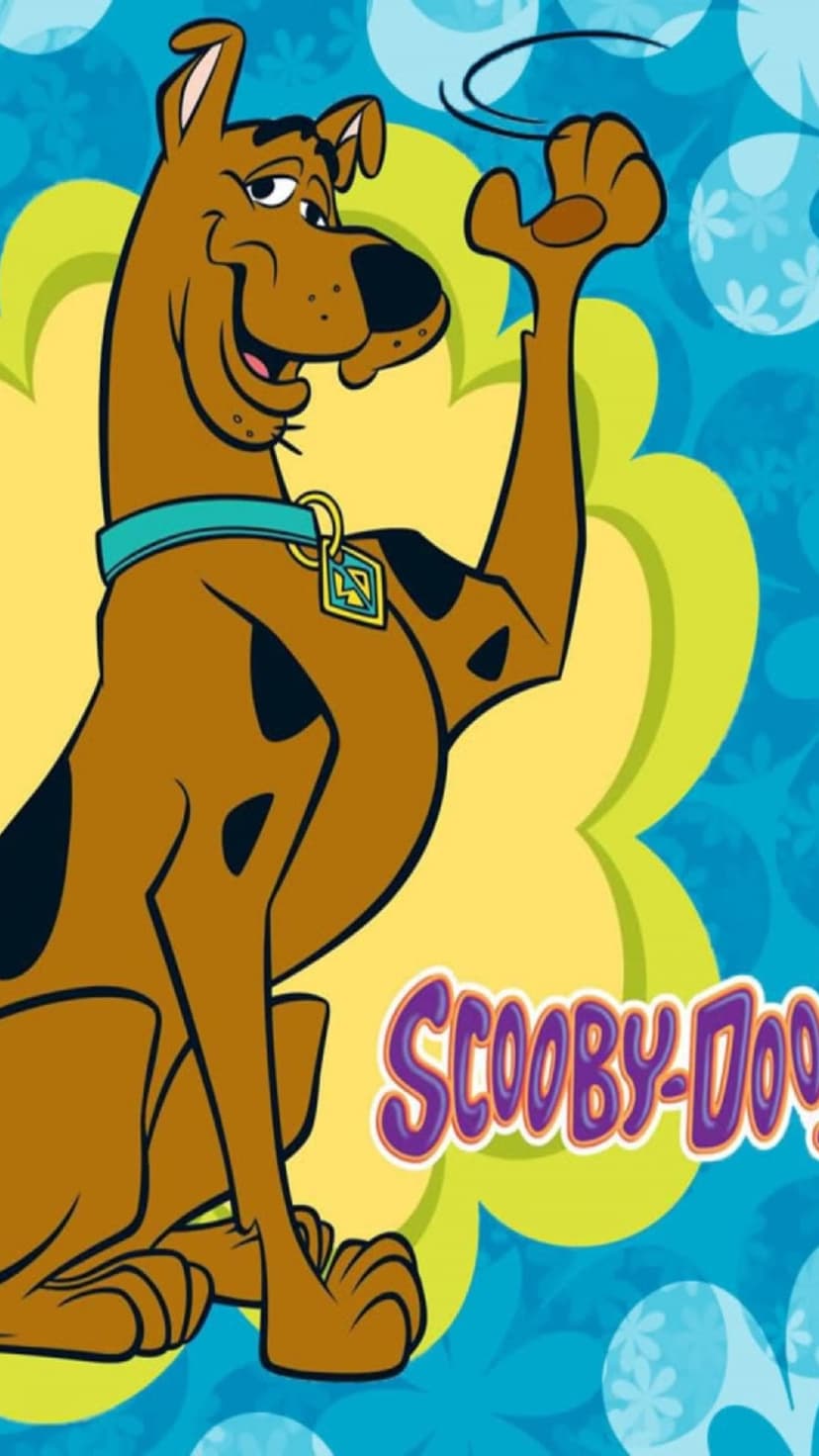 Scooby-Doo the brown Great Dane sits smiling in a blue collar before a yellow bubble and blue flower patterns.