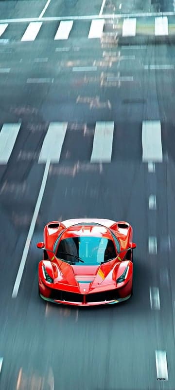 Red Ferrari Speeds Down Wet Road with Pedestrian Crossing