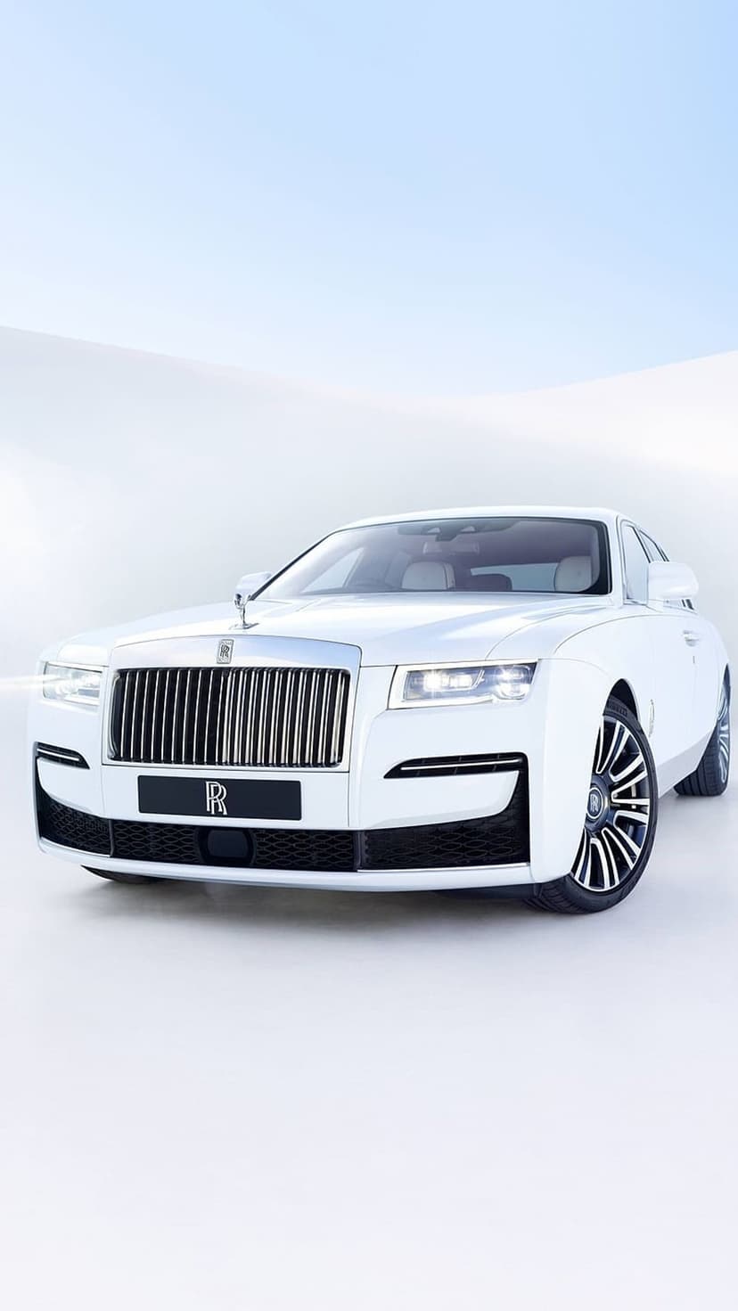 White Rolls-Royce Ghost sedan features a chrome grille and Spirit of Ecstasy ornament on a light background.