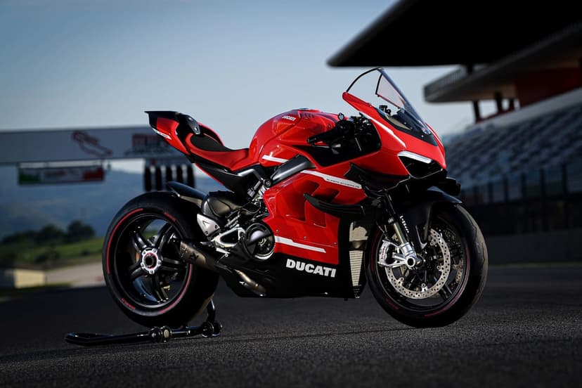 Ducati Superleggera V4 motorcycle in red and black on a racetrack with a blurred grandstand background.