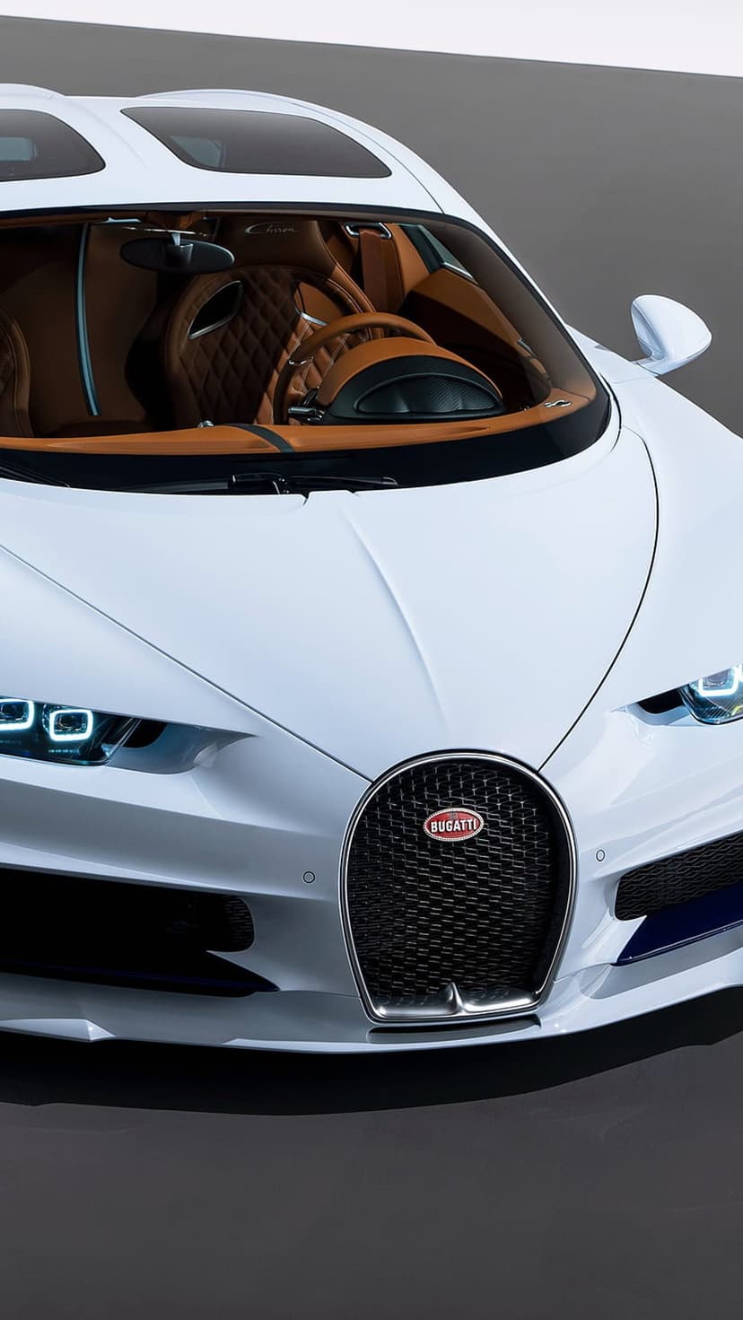 White Bugatti Chiron front grille and LED headlights adjacent to a brown quilted leather interior and sunroof.