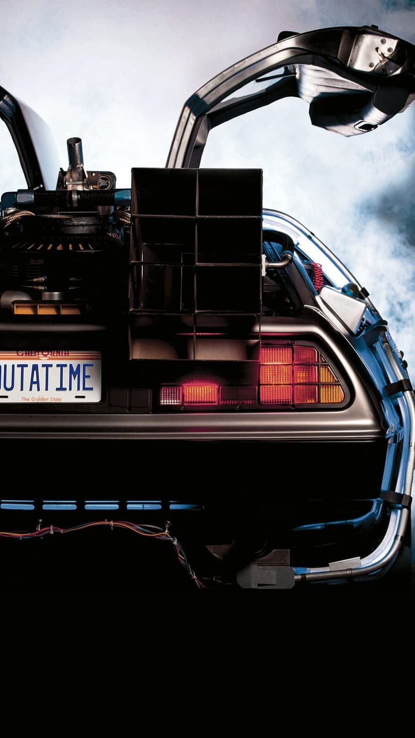 OUTATIME license plate on a silver DeLorean time machine with red rear lights and mechanical cooling vents.