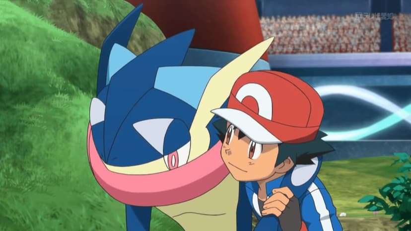 Ash Ketchum and Ash-Greninja stand together in a stadium with a blurred crowd and green grass background.