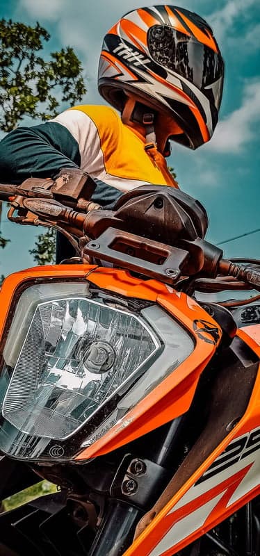 Motorcyclist in Orange and White Gear on Motorcycle