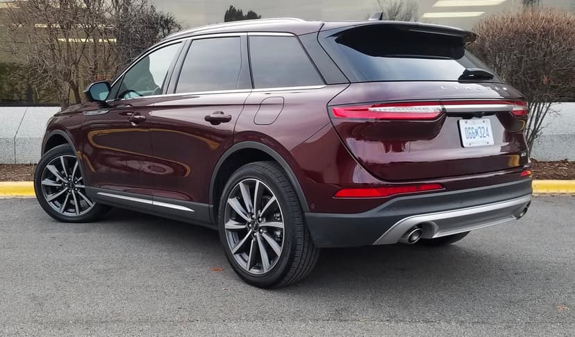 Rear three-quarter view of a burgundy Lincoln Corsair SUV parked on asphalt with silver alloy wheels.