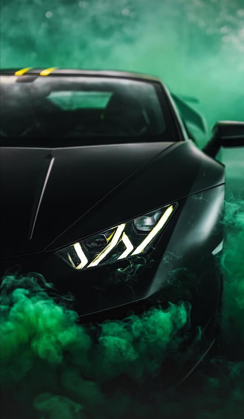 Black Lamborghini with glowing headlights emerges from thick swirls of vibrant neon green smoke and vapor.