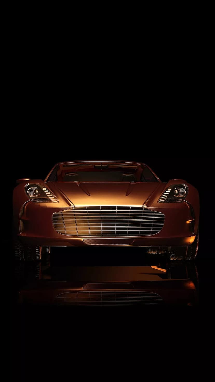Copper sports car front view with glowing headlights and a sleek grille against a solid black background.