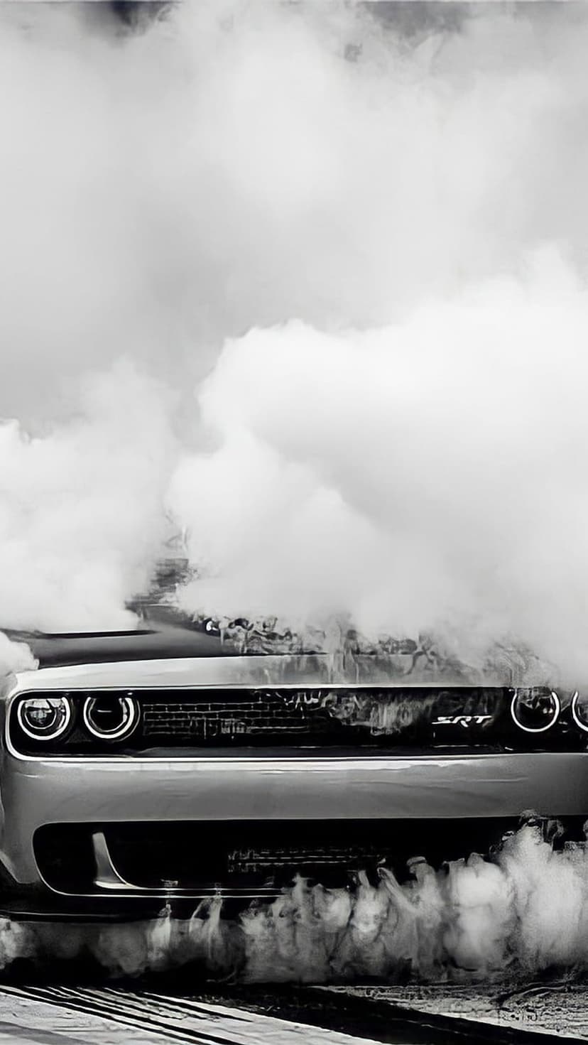 Dodge Challenger SRT Demon muscle car partially obscured by thick smoke plumes in a monochrome action shot.