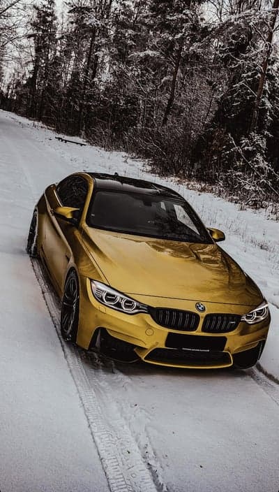 Golden BMW M4 on Snowy Forest Road