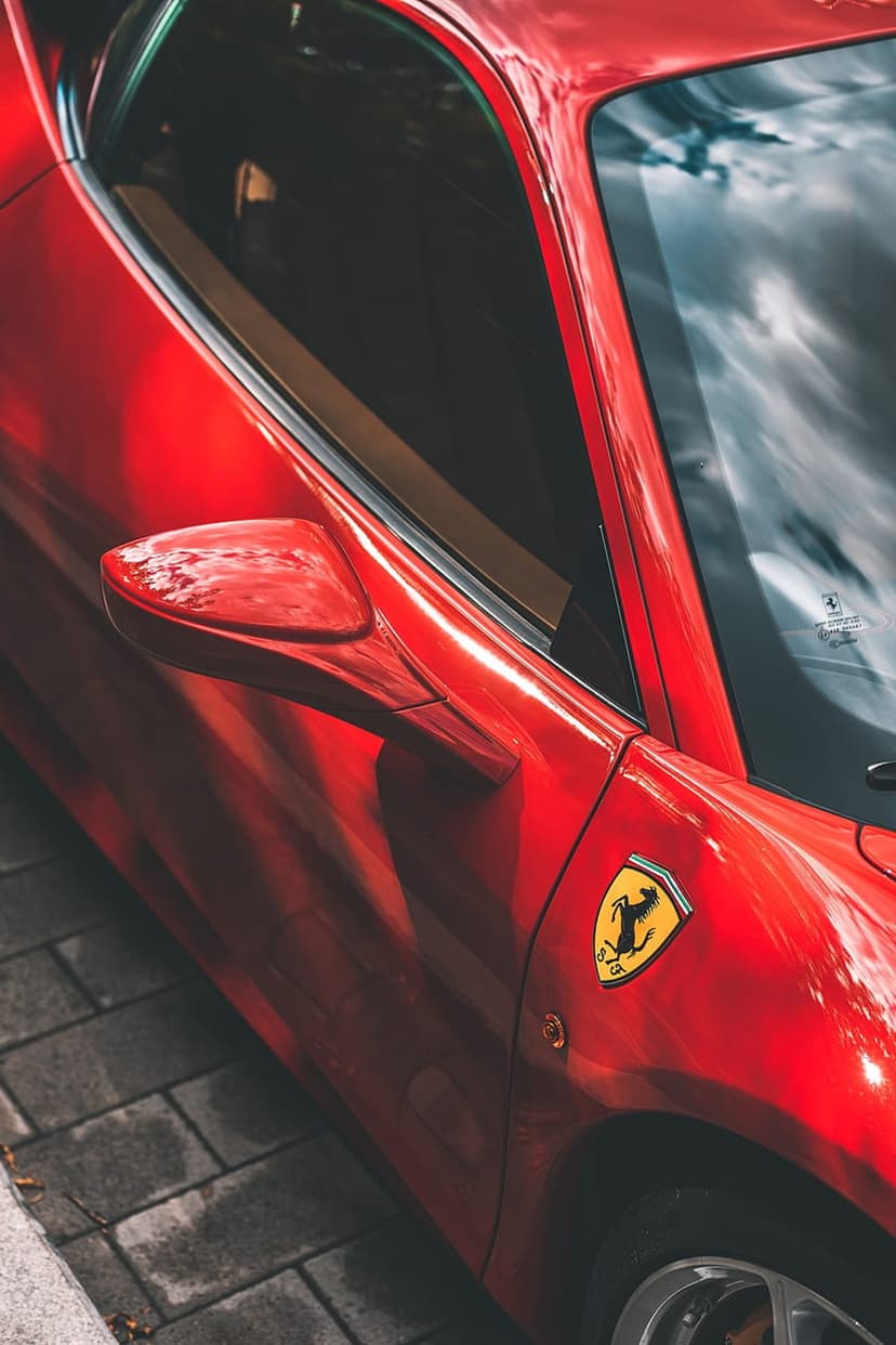Ferrari Prancing Horse emblem on a glossy red car door with reflections, designed as a vertical phone background.