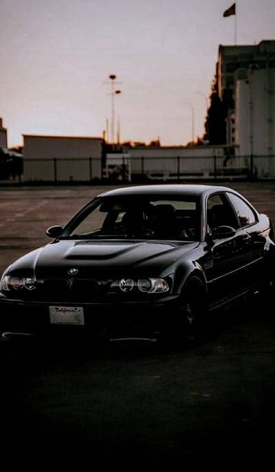 Black BMW M3 coupe parked at sunset with California license plate