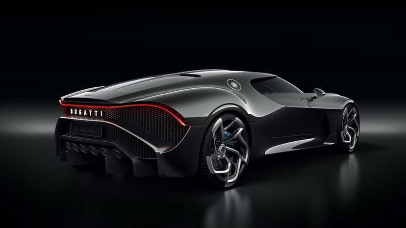 Rear view of a black Bugatti La Voiture Noire hypercar with red taillights in a dark reflective studio setting.