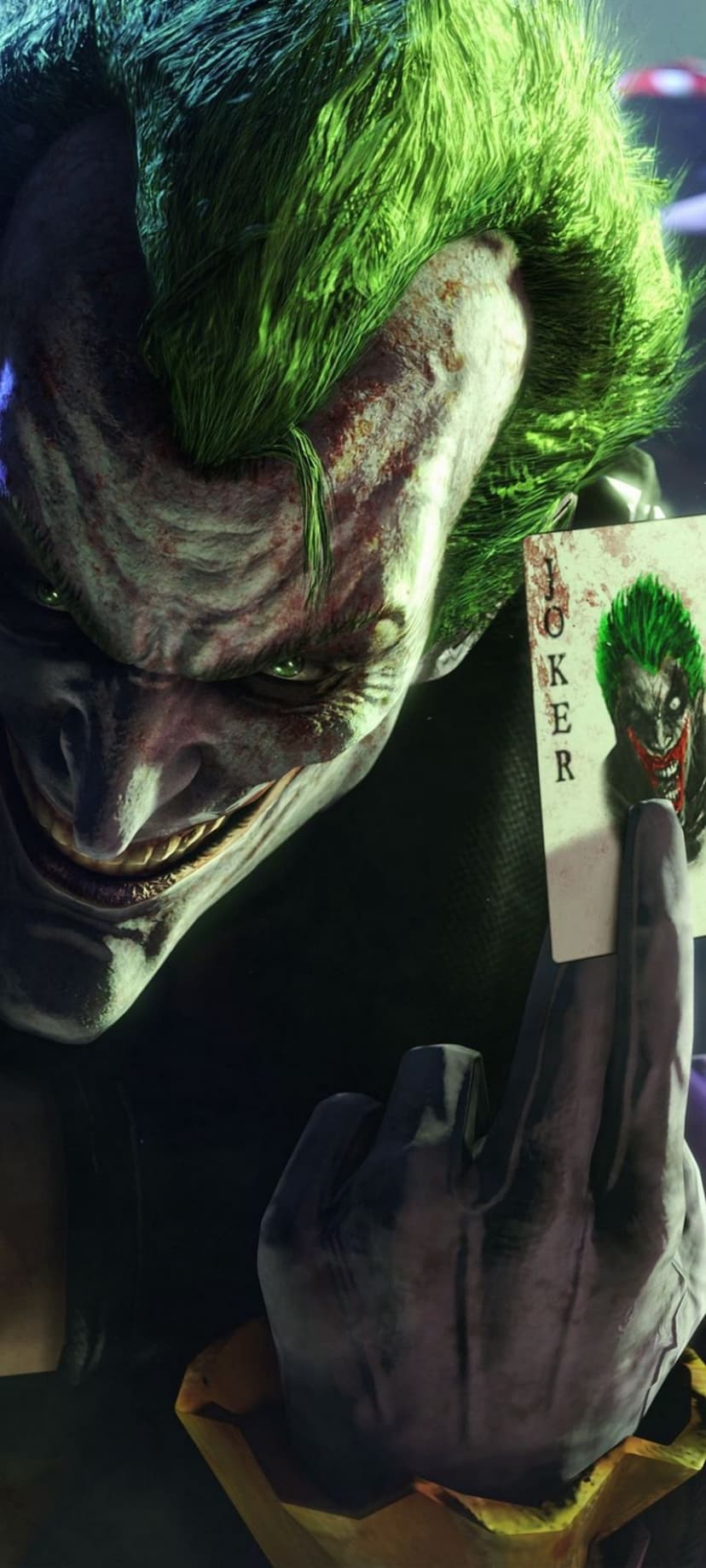 Joker with green hair holds a playing card showing his disfigured face against a dark, moody background.