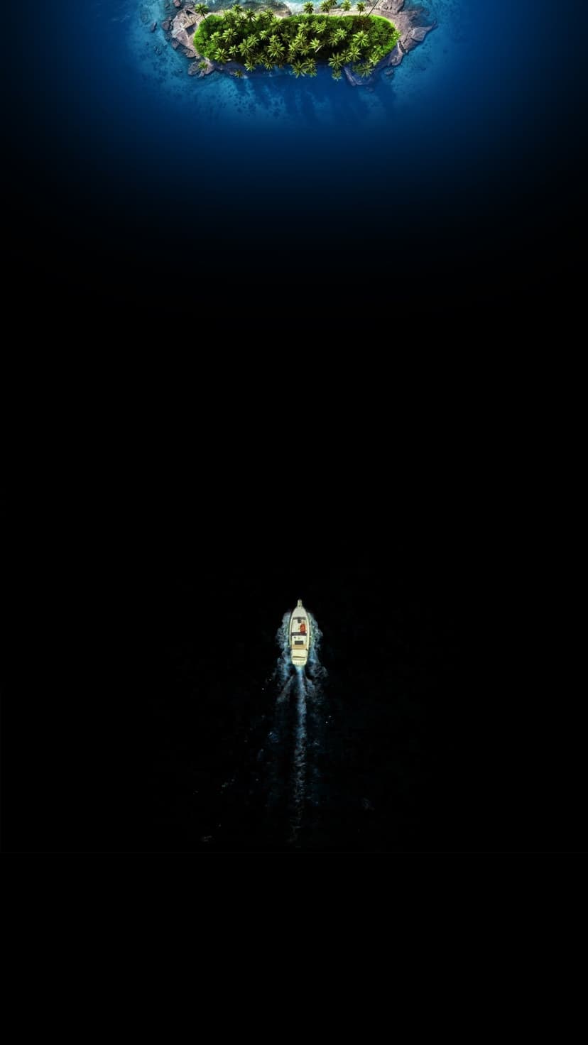 Small white boat leaving a wake in dark blue water while approaching a green tropical island from above.