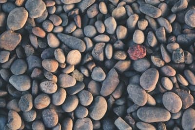 Close-up of Smooth River Rocks with a Red Stone Accent