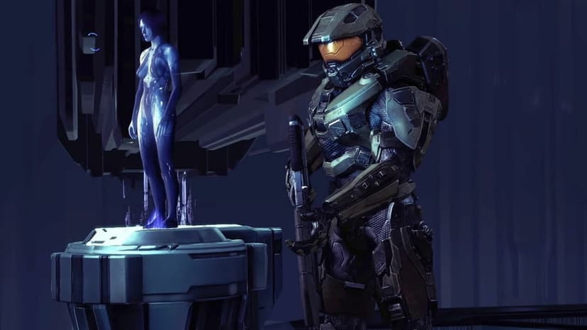Master Chief in green armor stands next to a blue holographic Cortana on a futuristic terminal pedestal.