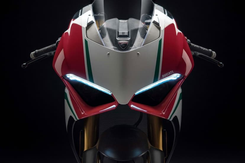 Front view of a Ducati Panigale V4 Speciale motorcycle with glowing LED lights and Italian flag colors.