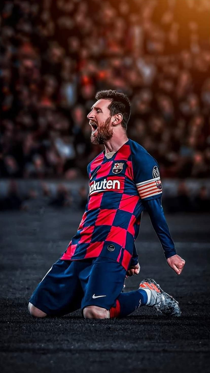 Lionel Messi kneeling and shouting in a red and blue checkered jersey with a blurred stadium in the background.