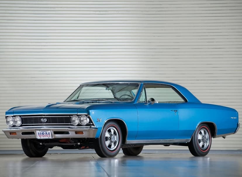 Blue 1966 Chevrolet Chevelle SS 396 classic muscle car with chrome accents parked against a white garage door.