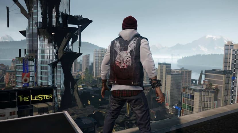 Man in a red beanie and denim vest stands on a rooftop looking out over a massive city and distant mountains.