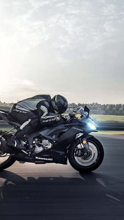 Kawasaki Motorcycle Racer Leaning into Turn on Track