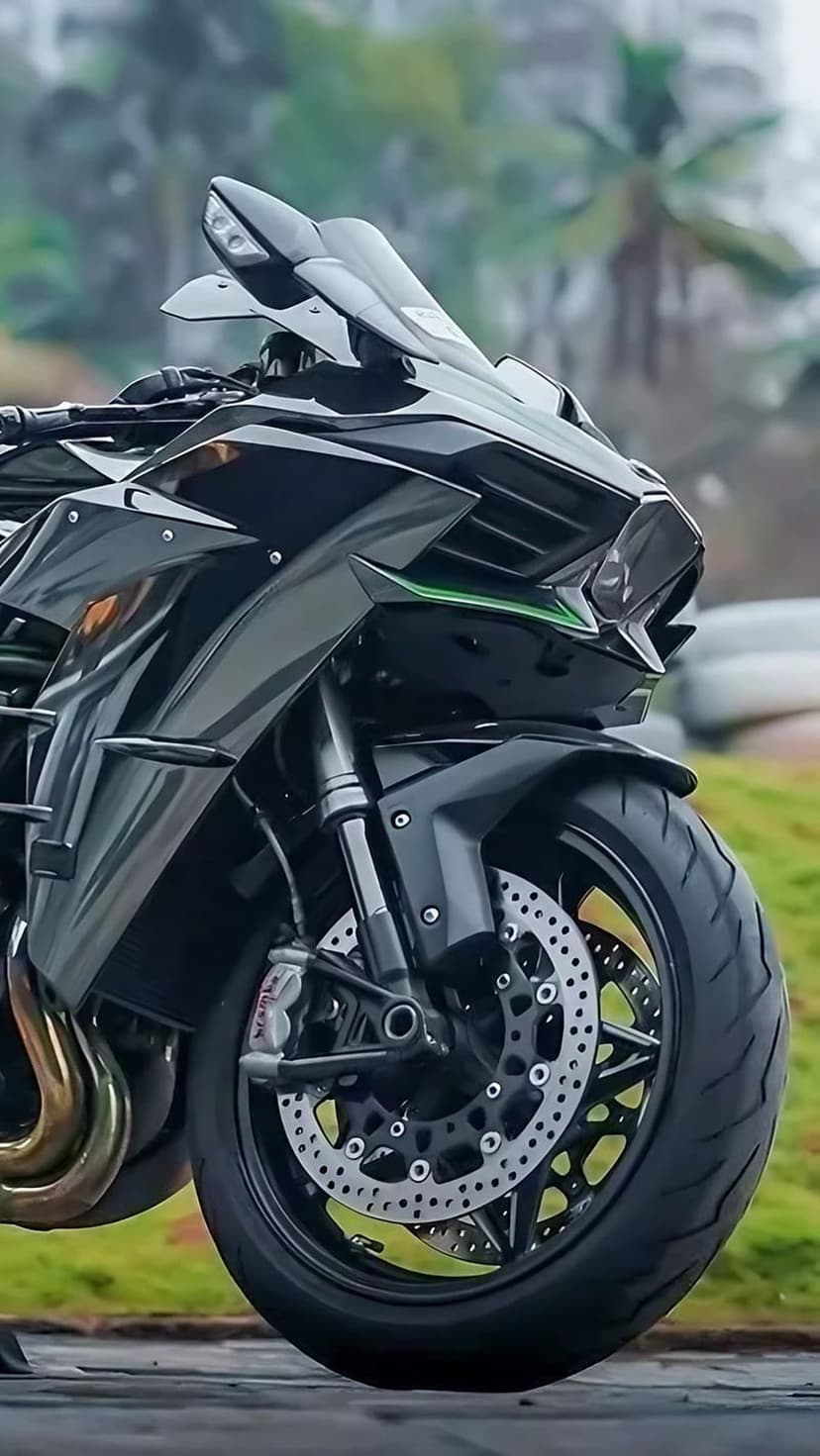 Kawasaki sportbike front wheel with Brembo brakes and a black fairing against a soft blurred background.