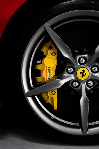 Ferrari Yellow Brake Caliper & Gray Rim Vertical Wallpaper