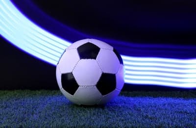 Soccer ball on grass with blue light streaks