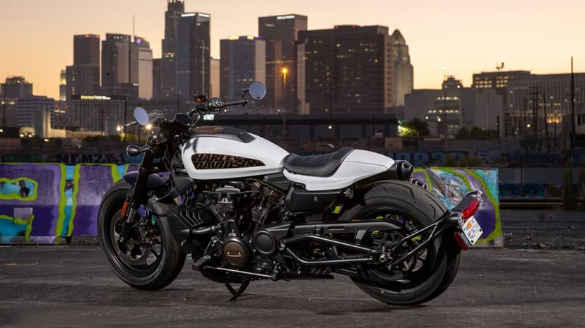 White Harley-Davidson Sportster S motorcycle parked in front of the Los Angeles skyline at dusk with graffiti walls.