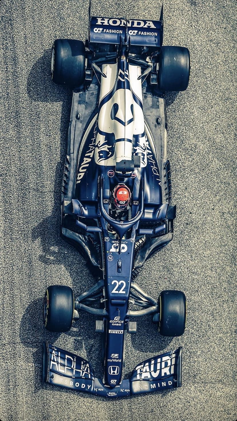 AlphaTauri F1 car number 22 with blue and white livery on a grey asphalt track viewed from directly above.