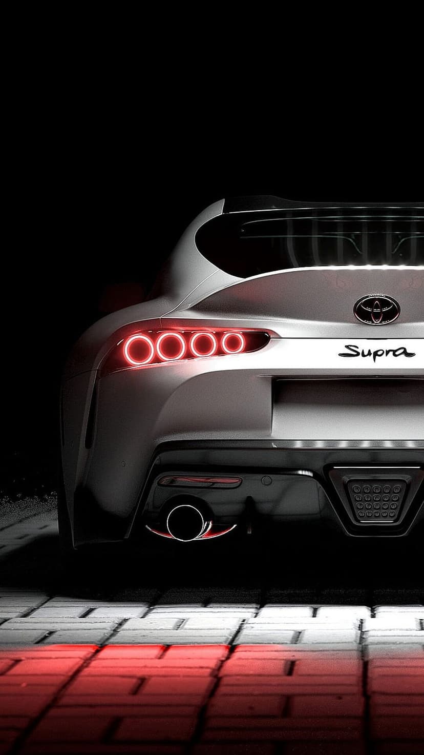 White Toyota Supra rear with glowing red circular taillights and reflective ground on a dark black background.